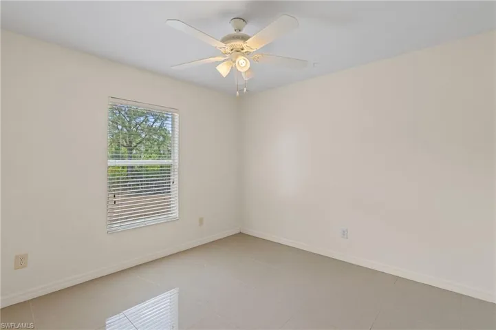 Unfurnished room with light tile patterned flooring and ceiling fan