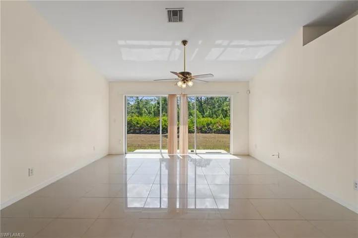 Unfurnished room featuring light tile patterned flooring and a ceiling fan