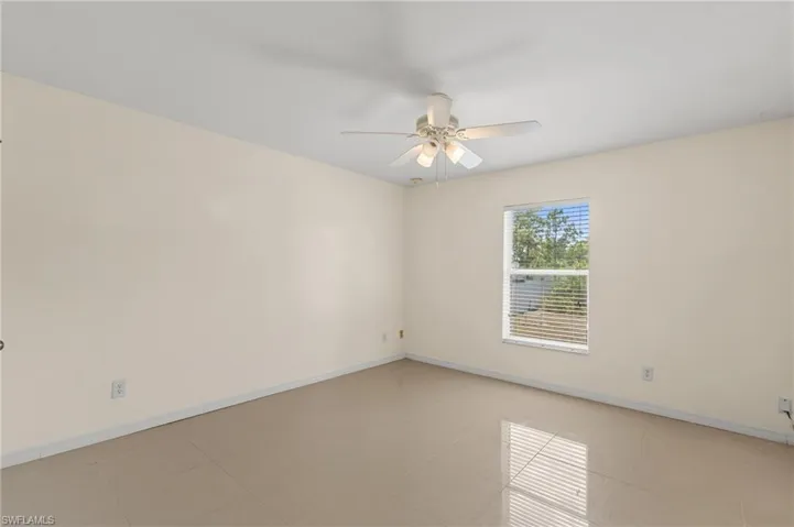 Unfurnished room featuring ceiling fan and light tile patterned floors