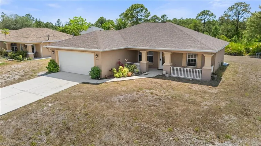 Single story home with stucco siding, driveway, roof with shingles, and an attached garage