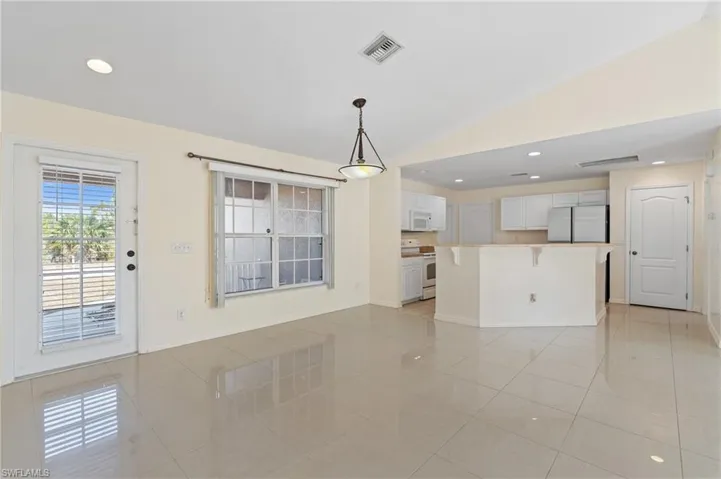 Unfurnished living room featuring recessed lighting, vaulted ceiling, and light tile patterned floors
