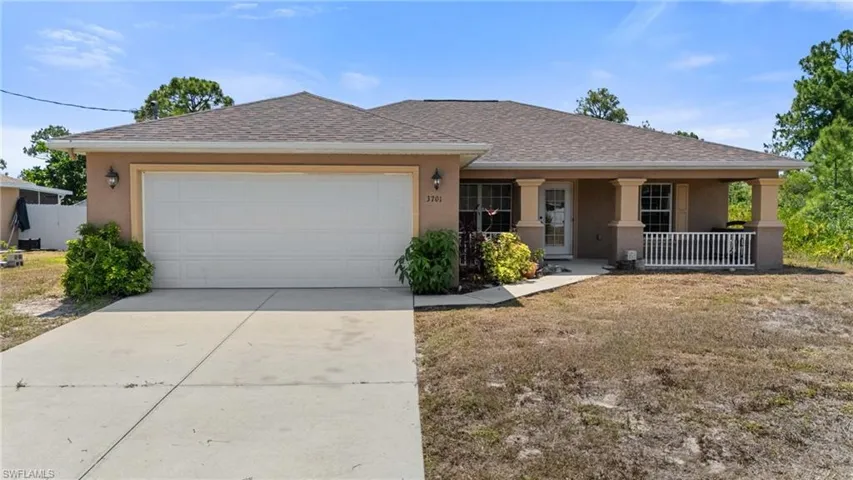 View of front of house with stucco siding, driveway, a porch, a garage, and roof with shingles