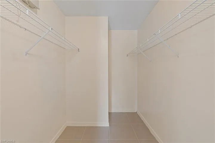Walk in closet with light tile patterned floors
