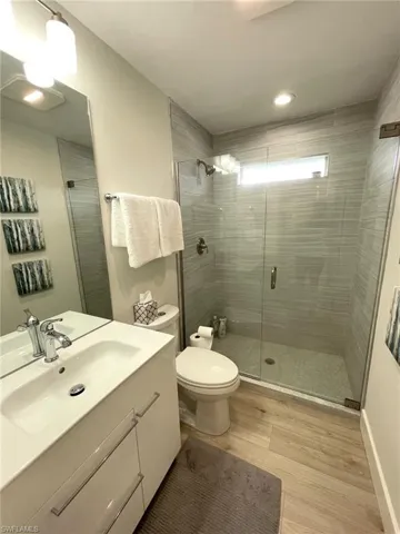 Full bathroom featuring vanity, a shower stall, and light wood-type flooring