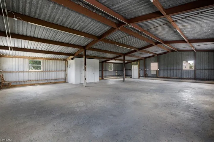 Misc room with concrete flooring, a garage, and metal wall