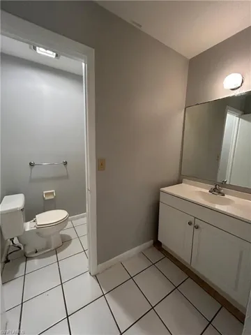 Half bath featuring vanity and light tile patterned floors