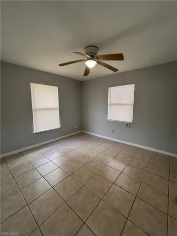 Spare room featuring light tile patterned floors and a ceiling fan
