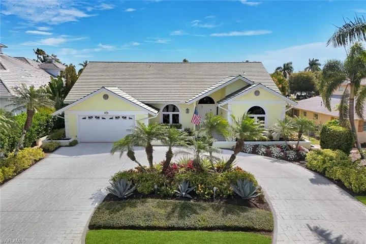 Ranch-style house with driveway, a tile roof, a garage, and stucco siding