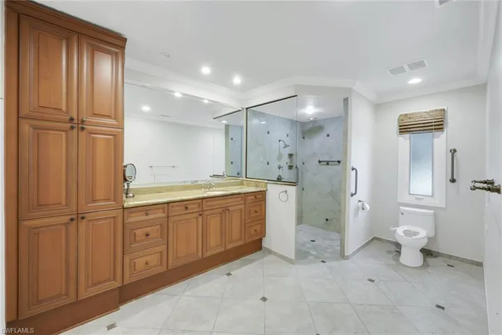 Full bathroom with vanity, a stall shower, ornamental molding, light tile patterned floors, and recessed lighting