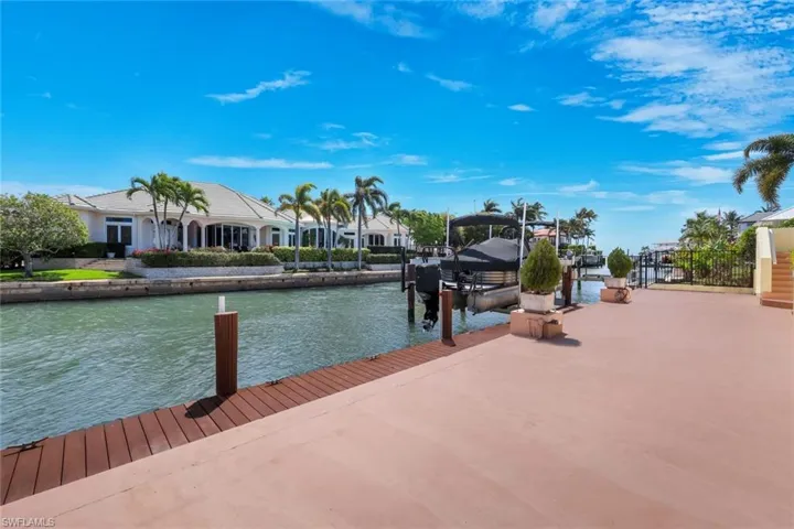 Dock with boat lift, a water view, and a residential view