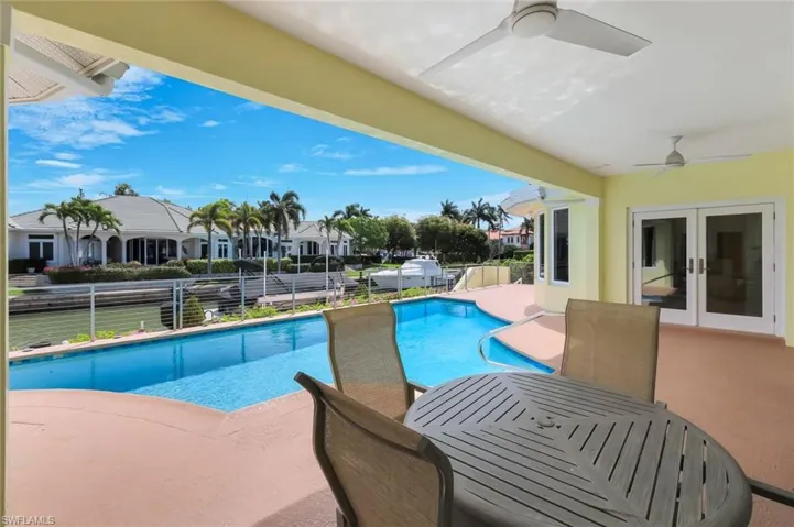 View of pool with french doors and patio surround