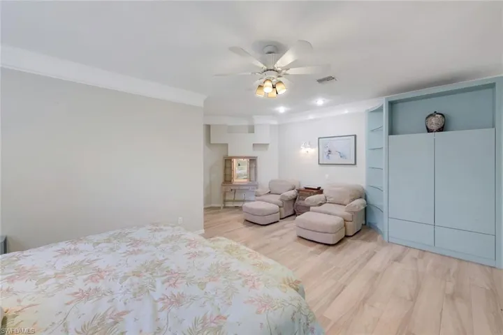 Bedroom with light wood finished floors, a ceiling fan, crown molding, and recessed lighting