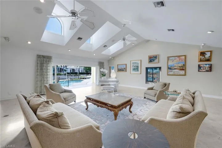Living area featuring a ceiling fan, a high ceiling, and recessed lighting