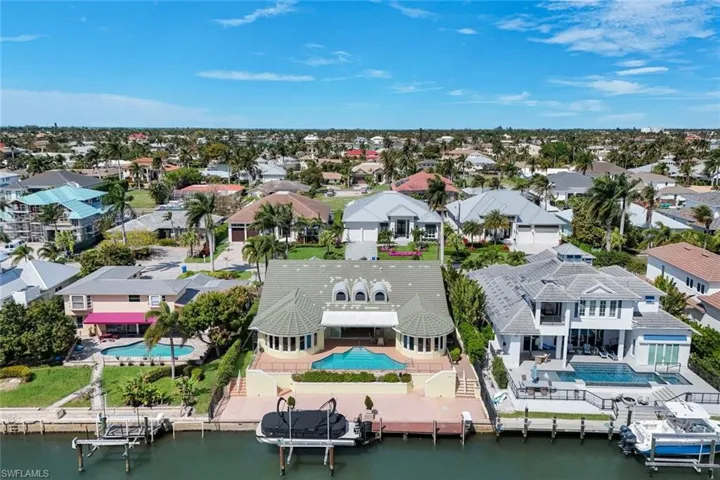 Aerial perspective of suburban area featuring a pool area and a large body of water