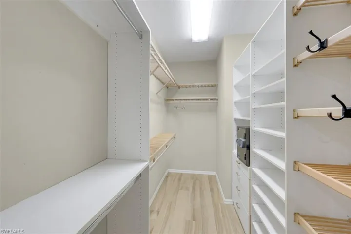 Walk in closet with light wood-style flooring