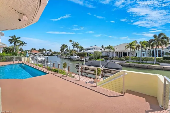 View of swimming pool with a water view, a boat dock, and a residential view