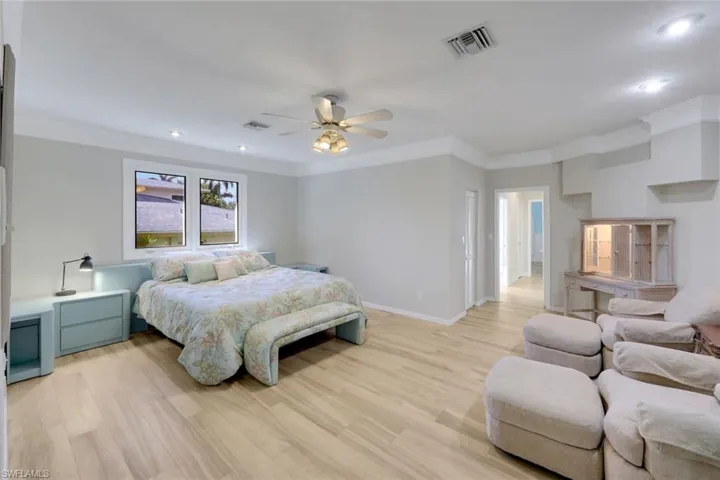 Bedroom featuring light wood-style floors, ornamental molding, ceiling fan, and recessed lighting