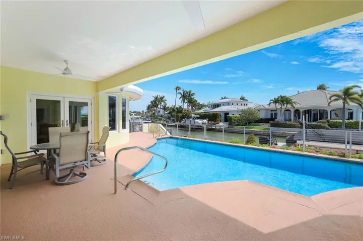 View of swimming pool with outdoor dining space, patio surround, and french doors
