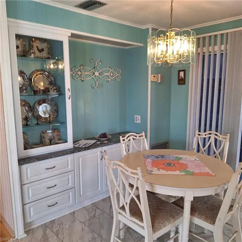 Dining space with ornamental molding and a chandelier