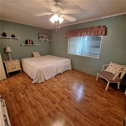 Bedroom featuring ceiling fan, ornamental molding, and light hardwood / wood-style floors