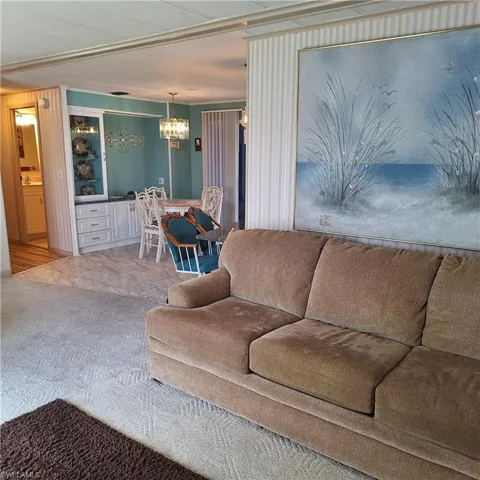 Carpeted living room featuring a chandelier