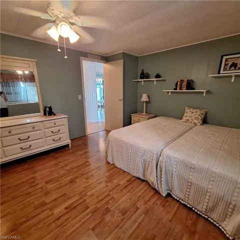 Bedroom featuring ornamental molding, light hardwood / wood-style floors, and ceiling fan