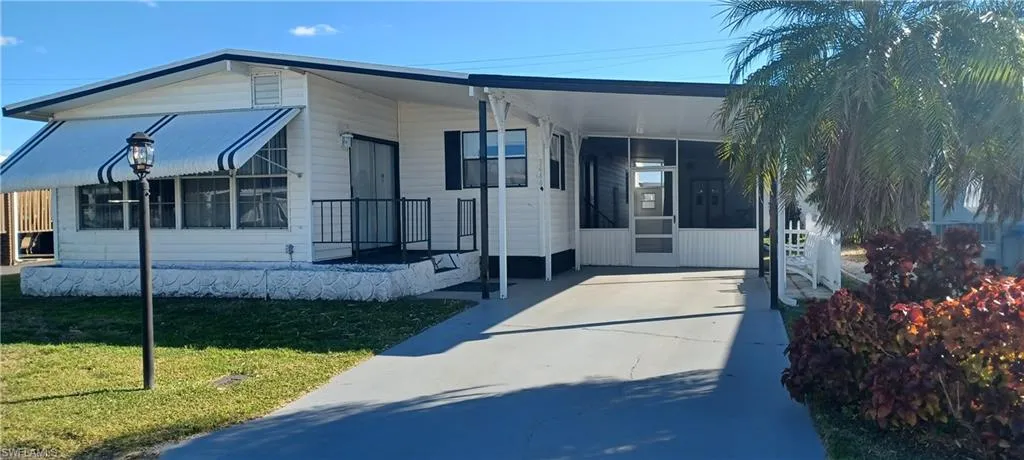 View of front facade with a front yard and a carport