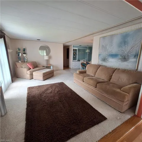 Carpeted living room featuring a chandelier