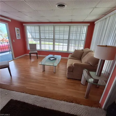 Living room featuring a drop ceiling and hardwood / wood-style flooring