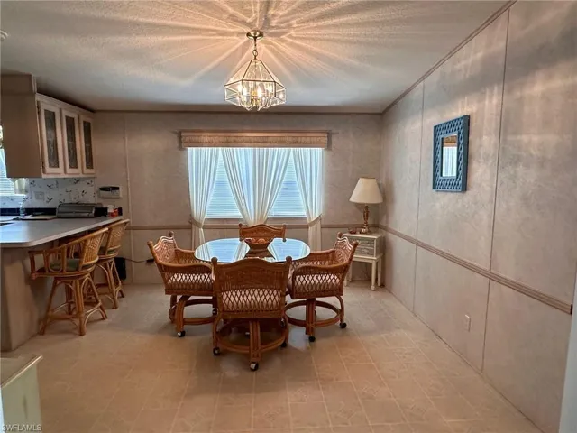 Dining area with a chandelier and a textured ceiling
