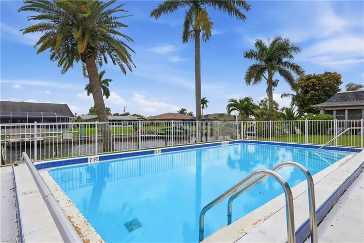 Community pool with a patio and a residential view