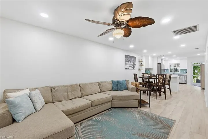 Living room with recessed lighting, ceiling fan, and light wood-type flooring