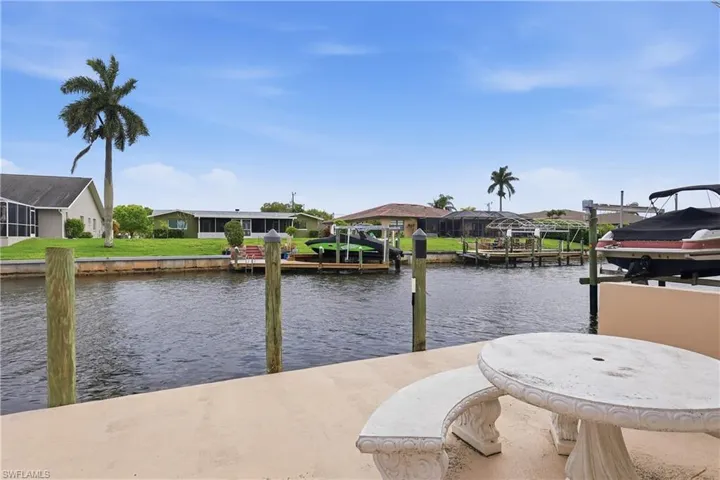 Dock with a water view, boat lift, and a residential view