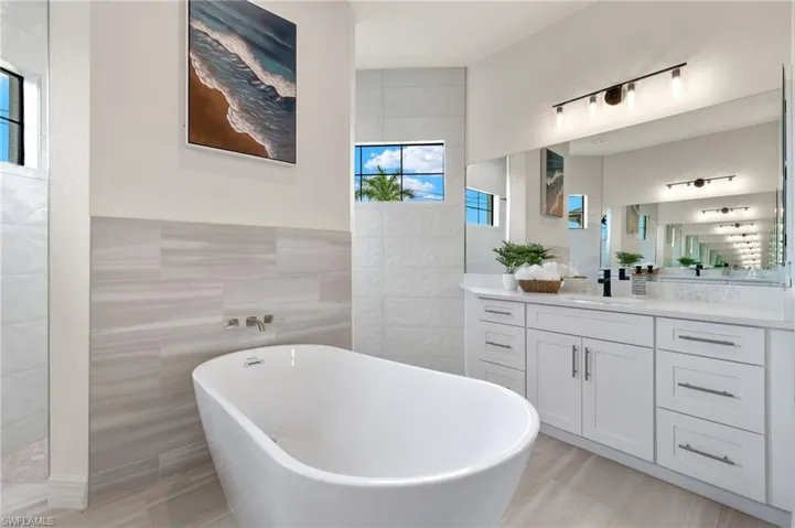 Bathroom featuring tile walls, tile flooring, and large vanity