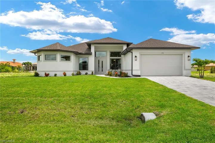 View of front of home with a garage and a front yard