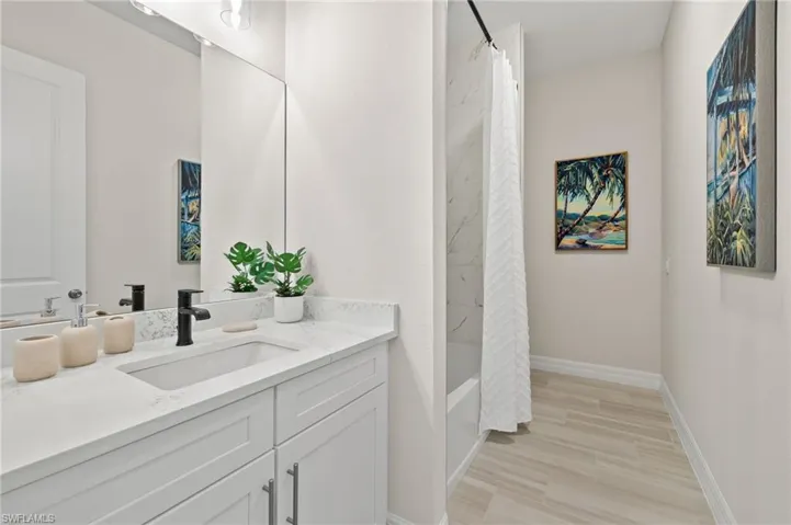 Bathroom with vanity with extensive cabinet space and shower / bath combo with shower curtain