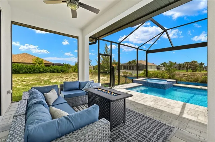 View of pool featuring a lanai, an in ground hot tub, ceiling fan, a patio, and an outdoor hangout area