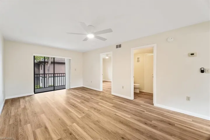 Spacious living room with new hardwood / wood-style floors and ceiling fan