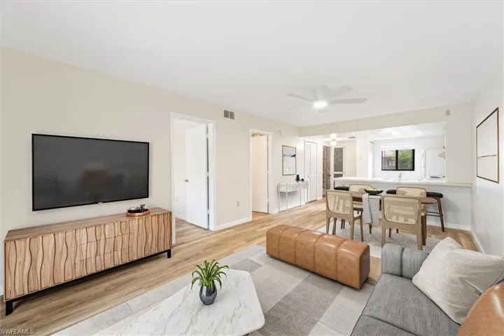 Living room with ceiling fan and light hardwood / wood-style floors with virtual staging