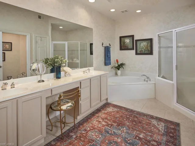 Full bath featuring a bath, a shower stall, double vanity, light tile patterned floors, and recessed lighting