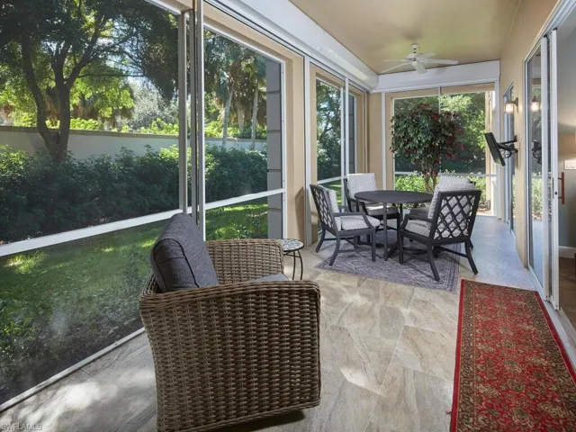 Sunroom / solarium featuring ceiling fan, stone finish floors, and outdoor dining space
