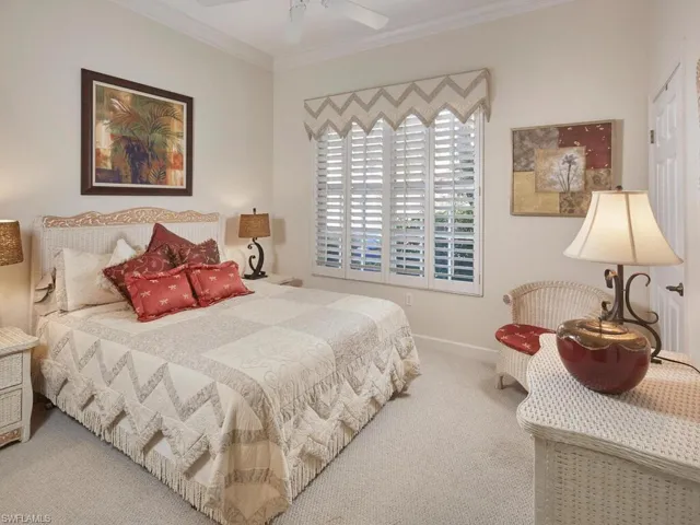 Bedroom with carpet floors, ornamental molding, and ceiling fan