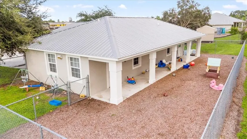 Rear view of property with a fenced backyard, a gate, stucco siding, and a patio area