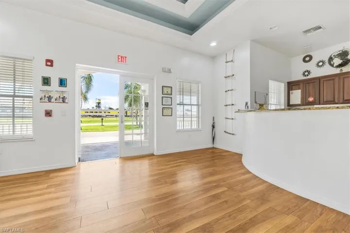 Foyer entrance with light wood-type flooring, a tray ceiling, and recessed lighting