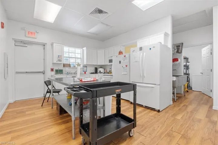 Kitchen featuring freestanding refrigerator and white cabinets