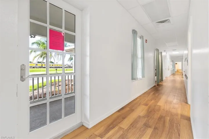 Hall featuring light wood-style floors and a paneled ceiling