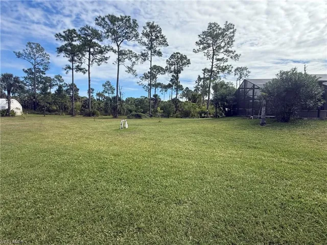 View of grassy yard featuring a lanai