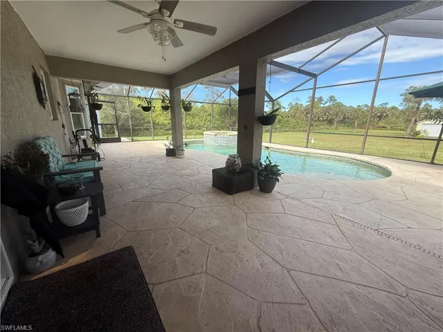 View of swimming pool featuring a patio, a sunroom, a lanai, and ceiling fan