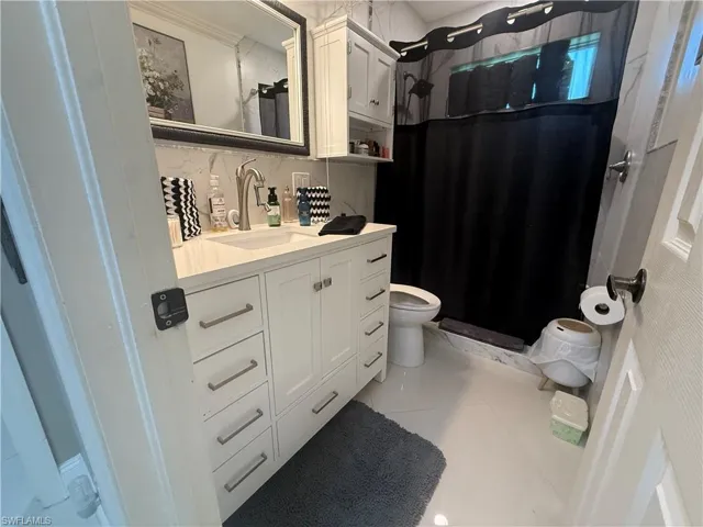 Bathroom featuring vanity, a shower stall, and light tile patterned floors