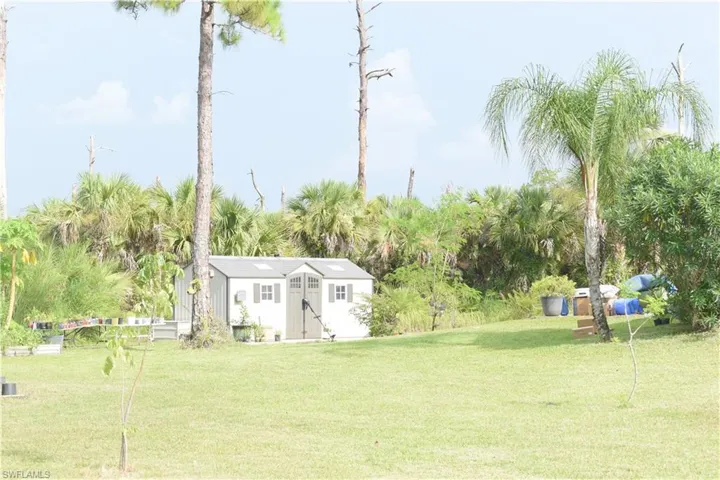 View of grassy yard featuring a storage shed